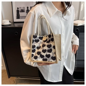 Detail of linen lunch bag featuring black heart pattern and rustic wooden button closure