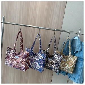 Detailed display of four colorful tote bags with ethnic geometric woven patterns on hangers