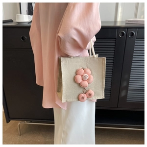Detailansicht der beigen Leinentasche mit rosa 3D-Blume und runden Quastenverzierung