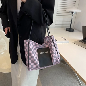Pink and grey checkered nylon tote bag worn by model in a minimalist study room setting