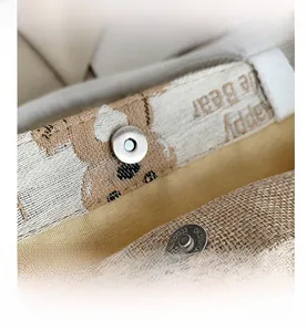 Macro shot of canvas tote bag with magnetic snap closure and cute brown bear print