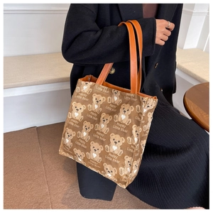 Detail shot of the printed bear patterns and faux leather handles on the canvas tote