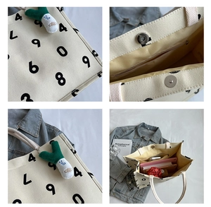 Detail view of canvas tote bag showing magnetic buckle, inner pocket and large number print