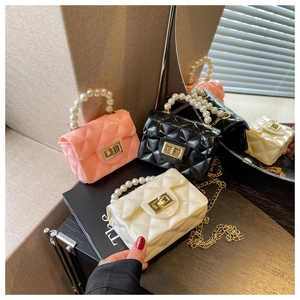 Detail of mini quilted jelly bags with pearl handles and gold chain straps in three colors