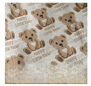 Detail of knit fabric with cute bear patterns and Happy Little Bear text on beige tote bag