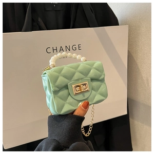 Detail of mint green jelly mini bag with quilted pattern, pearl handle, and gold chain