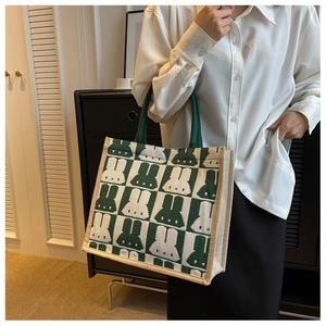 Close-up of green checkerboard tote bag with woven texture and rabbit silhouettes