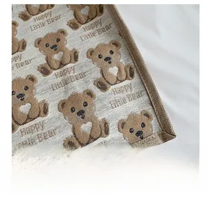 Close-up of woven canvas bag featuring brown bear print and Happy Little Bear text