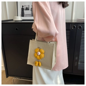 Detail der Leinentasche mit gelber 3D-Blume und geflochtenem Baumwollgriff für Damen