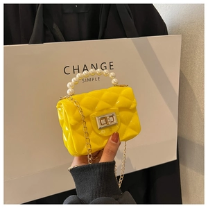 Close-up of bright yellow mini jelly bag with pearl handle and metal chain strap