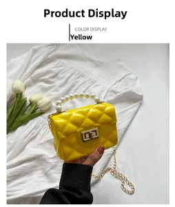 Detail of yellow quilted jelly bag featuring pearl handle and golden chain strap