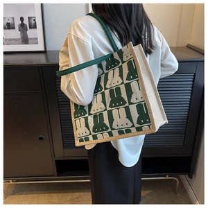 Detail of green checkerboard tote bag with rabbit pattern and round rope handles