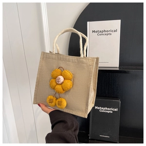 Detailansicht der Jute-Tasche mit gelber 3D-Stoffblume und weißen Baumwollseilgriffen
