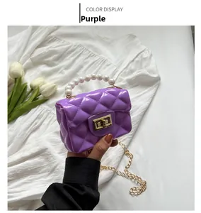 Detail of purple jelly crossbody bag featuring quilted texture and faux pearl handle