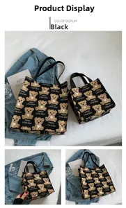 Detail view of black canvas tote bags featuring brown bear patterns and sturdy handles