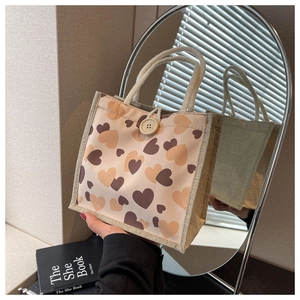 Detailed shot of heart print linen tote bag with cotton rope handle and button closure