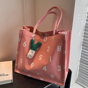 Pink canvas tote bag with white number print and plush onion pendant on white background