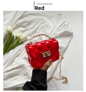 Detail of red quilted mini jelly bag with pearl handle and golden chain strap