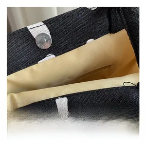 Detail of black polka dot canvas tote showing magnetic closure and interior lining