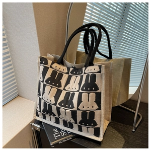 Detail of canvas tote bag with black and white checkerboard and pixel rabbit pattern