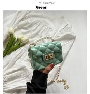 Close-up of mint green jelly bag with pearl handle and golden chain strap details