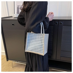 Dettaglio della borsa tote in lino pied-de-poule con bordo marrone e manico in corda