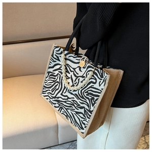 Detail of zebra pattern canvas tote with pearl chain and wooden button closure