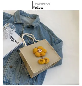 Detailaufnahme einer Leinen-Lunchtasche mit gelber Sonnenblume und Baumwollseil-Tragegriffen