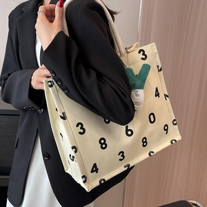 Large beige canvas tote bag with black number prints and white woven rope handles