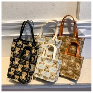 Detail of canvas tote bags with cartoon bear prints in black, beige and brown colors