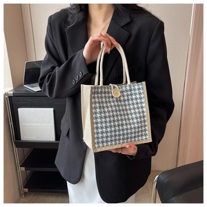 Dettaglio borsa in lino con motivo pied de poule e chiusura con bottone in legno