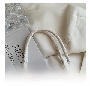 Detailed close-up of the soft braided cotton handles on this beige canvas lunch bag