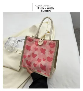 Detail of pink tie-dye jute lunch bag featuring red hearts and a wooden button closure