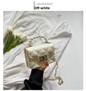 Detail of beige jelly mini bag featuring diamond quilt pattern and pearl top handle