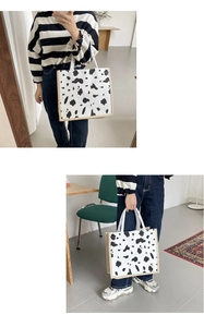 Detail of cow print canvas tote bag featuring natural jute trim and durable handles
