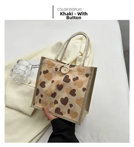 Detail of khaki linen tote bag with heart pattern and natural wooden button closure