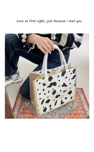 Detail of cow print canvas tote bag with hemp sides and woven rope handle