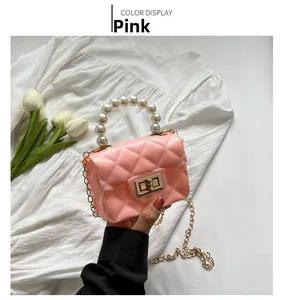 Detail of pink jelly mini bag with quilted pattern, pearl handle and gold chain strap
