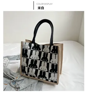 Detail of beige canvas tote bag featuring black and white checkered rabbit pattern print