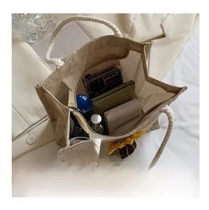 Internal capacity of beige linen tote bag showing phone, wallet and cosmetics inside