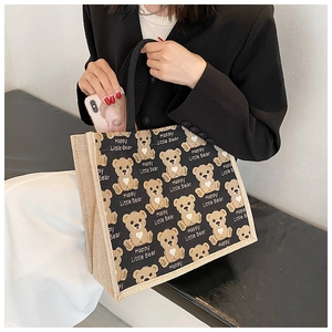 Detail of canvas tote bag with Happy Little Bear print and reinforced black handles