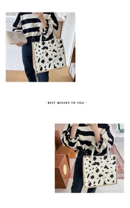 Detail of large canvas tote bag with cow print pattern and natural jute trim edges