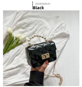 Detail of black quilted mini bag with pearl handle and golden chain strap for girls