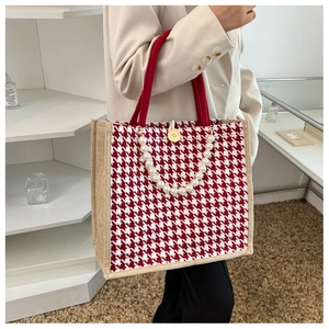 Detail of houndstooth tote with jute side panels, pearl strap, and wooden button