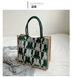 Detailed knit tote bag with green checkered patterns and pixelated bunny graphics