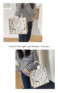 Detail of canvas tote bag with black graffiti prints and natural jute handles