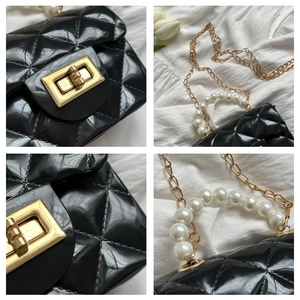 Detail view of black jelly bag showing quilted pattern, pearl handle and gold lock