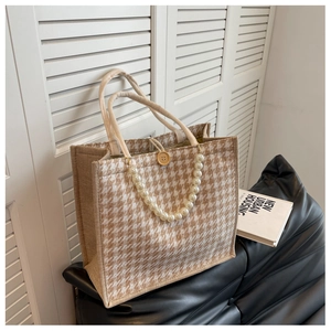 Detail of houndstooth tote bag with large pearl chain and rustic wooden button