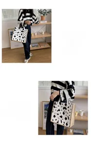 Detailed view of canvas tote bag with black and white cow print and sturdy woven handles