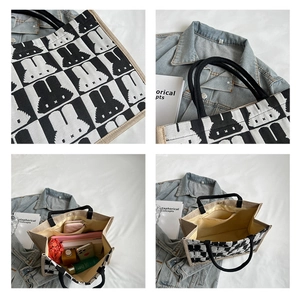 Detail view of large canvas tote bag with rabbit silhouette pattern and cotton rope handle